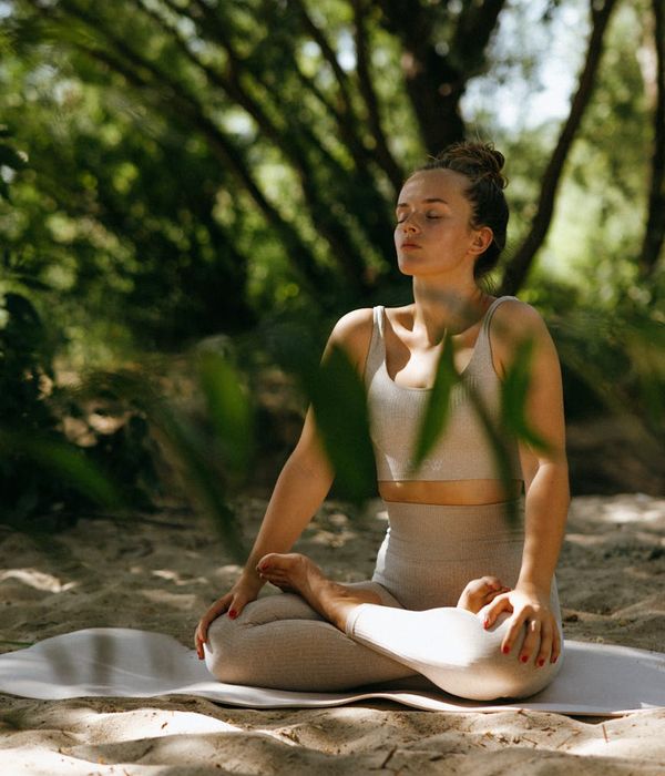 A person meditating peacefully outdoors in a natural setting.